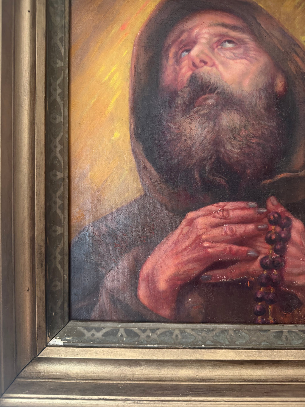 Close-up showing age-related surface wear on the carved frame of Saint Francis of Paola