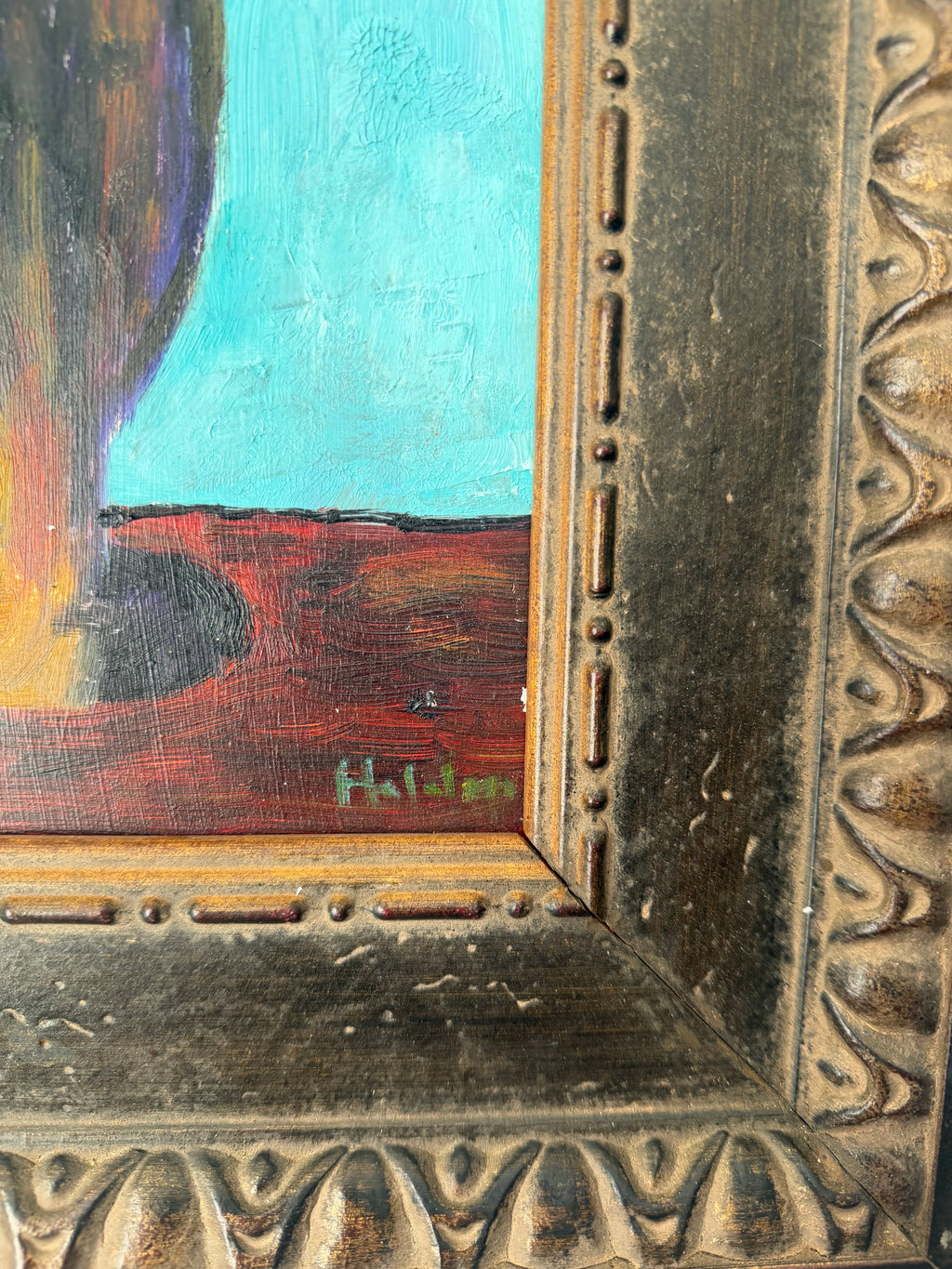Close-up showing the artists signature and decorative details on the vintage frame