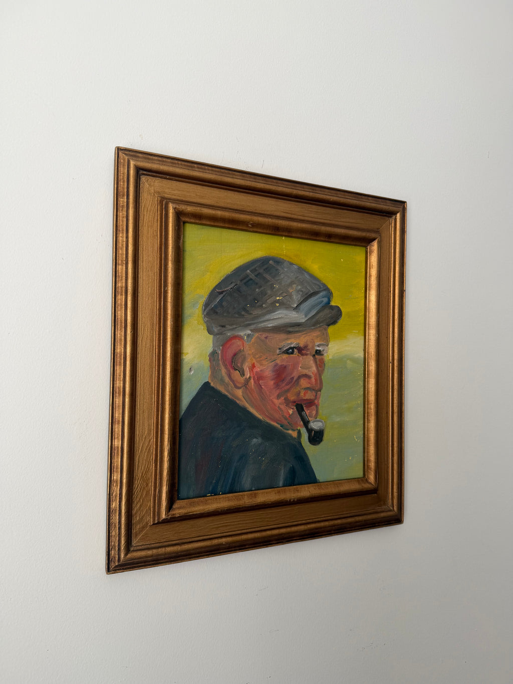 Angled view of a vintage pipe smoker portrait in its gilt wood frame