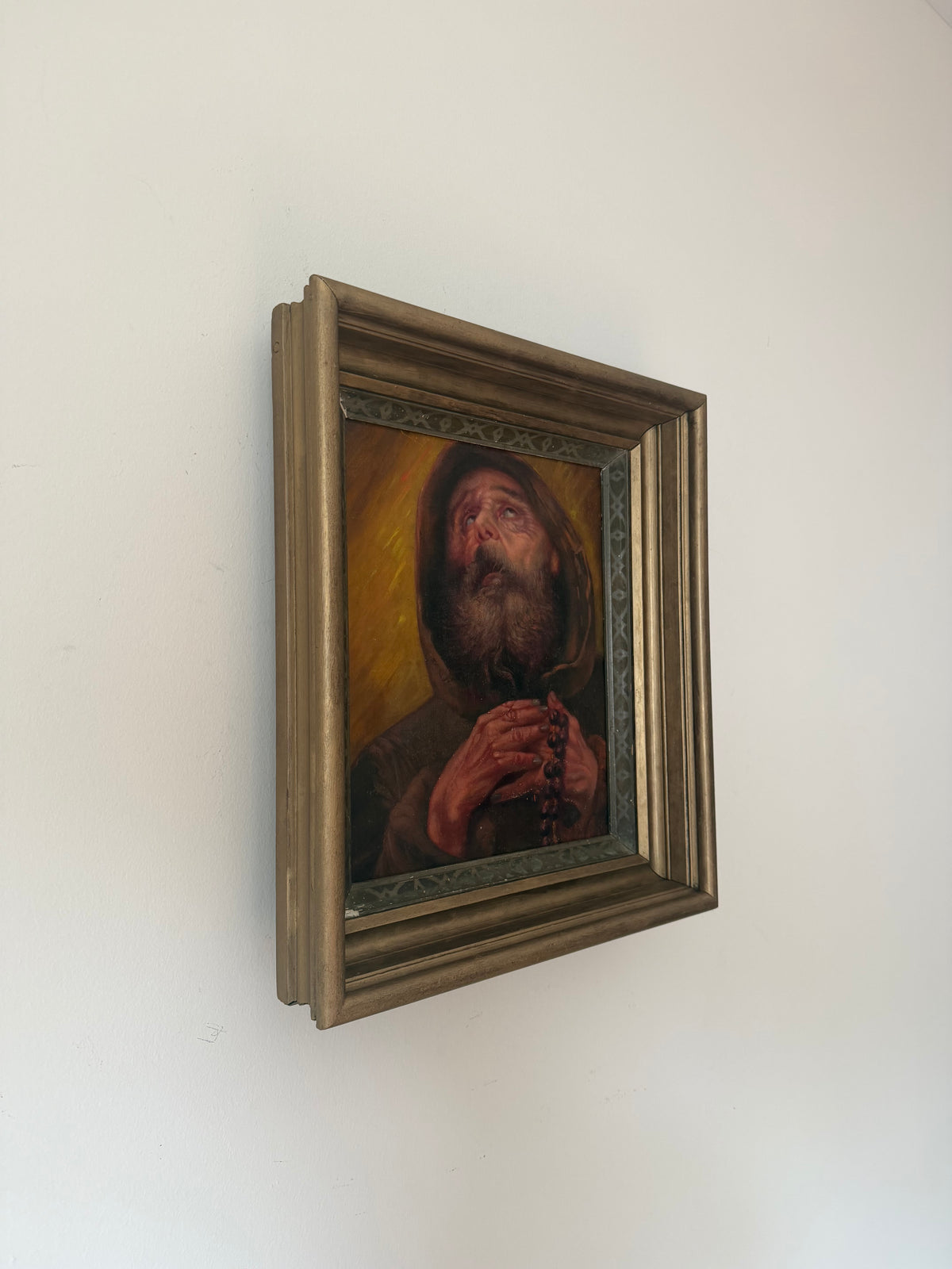 Angled view of the framed antique Saint Francis of Paola devotional painting